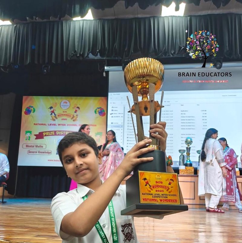 Student raising the National Wonderkid trophy on stage